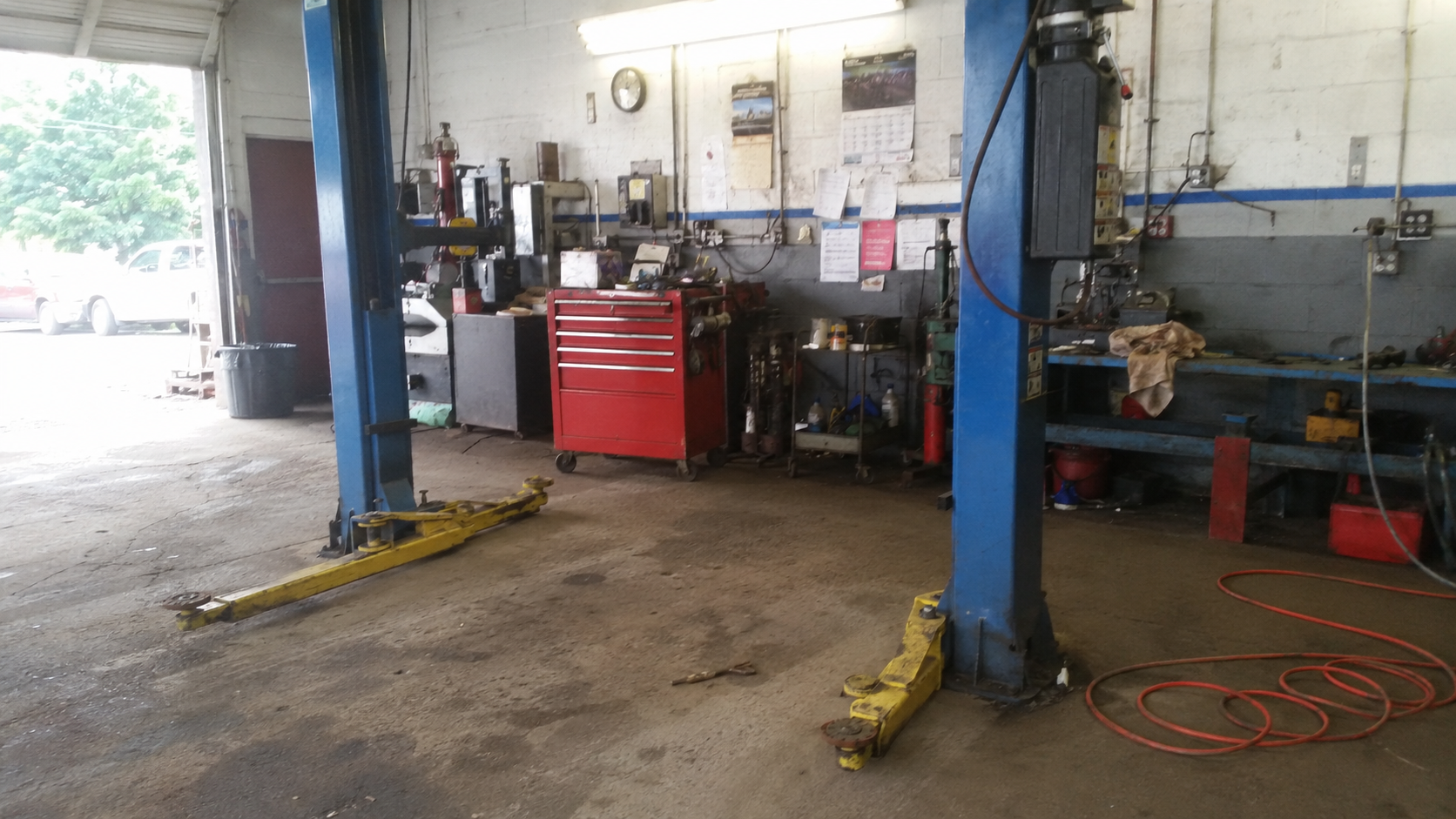 Empty bay in an independent auto repair shop, two-post lift ready